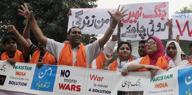 Eine Menschenmenge mit orange-farbenen Schals bei einer Demonstration