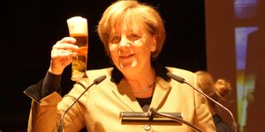 Angela Merkel hebt ein Glas