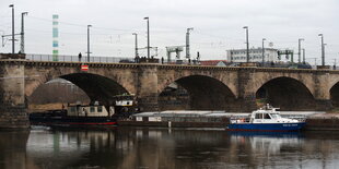 ein Schubverband fährt unter einer steinernen Brücke hindurch