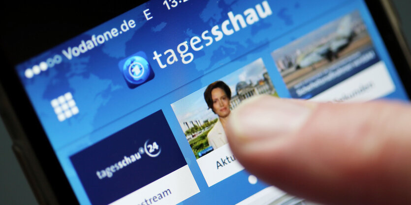 Ein Finger zeigt auf ein Smartphone auf der die Tagesschau-App läuft