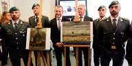Die Mitarbeiter der Guardia di Finanza stehen neben den wiedergefundenen Van-Gogh-Gemälden