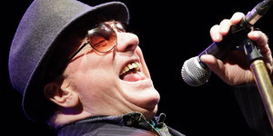 Van Morrison trägt Hut und Sonnenbrille und sind mit Leidenschaft ins Mikrofon