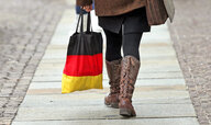 Eine Frau geht mit einer Einkaufstasche in schwarz-rot-gold durch die sächsische Kleinstadt Döbeln.