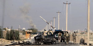 Ein Militärauto neben einem ausgebrannten Wrack