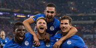 vier feiernde Fußballer in blauen Trikots