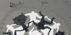 tanzende schwarze und weiße Figuren als Straßenmalerei vor dem Eiffelturm