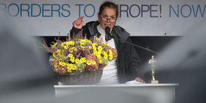 Tatjana Festerling steht an einem Rednerpult und gestikuliert, vor ihr ein Korb mit Blumen