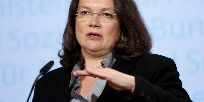 Andrea Nahles vor einem Mikro. Sie macht mit der Hand eine Schnitt-Bewegung