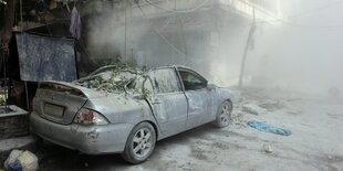 Ein Mercedes vor einem Mehrfamilienhaus. Alles ist mit einer dicken Staubschicht bedeckt.