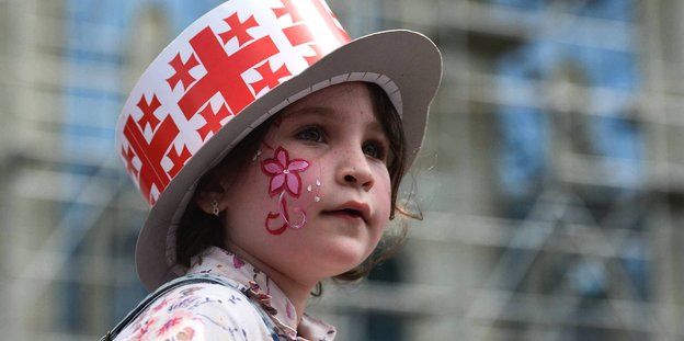 Mädchen trägt einen Hut mit dem georgischen Wappenmuster