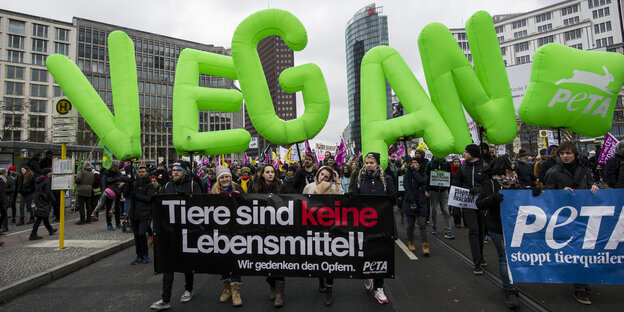 Demonstranten gehen am 16.01.2016 mit großen "Vegan"-Buchstaben in Berlin am Potsdamer Platz vorbei
