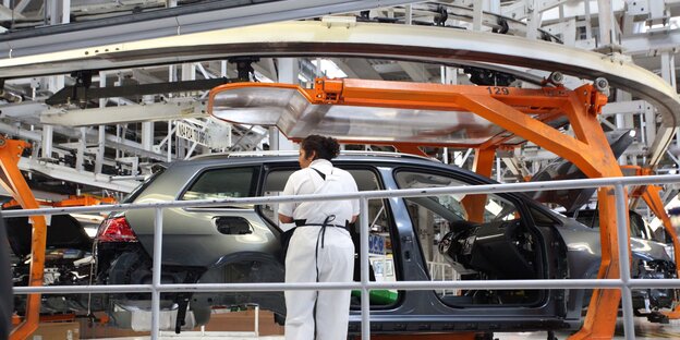 Eine Mitarbeiterin eines VW-Werkes in Pueblo, Mexiko, steht am Fließband.