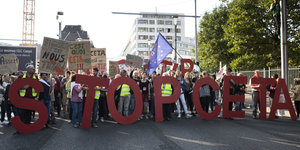DemonstrantInnen tragen Buchstaben auf einer Straße: Stop Ceta