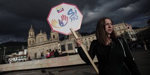 Eine junge Frau hält ein Schild, auf dem "Si" steht