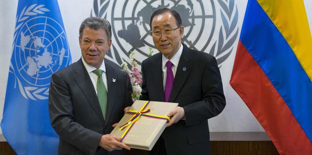 Der Kolumbianische Präsident Juan Manuel Santos hält zusammen mit Ban Ki Moon das Friedensabkommen mit der Farc