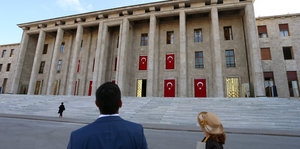 Ein Mann und eine Frau stehen vor dem türkischen Parlament in Ankara