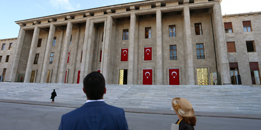 Ein Mann und eine Frau stehen vor dem türkischen Parlament in Ankara