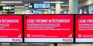 Rote Werbetafel mit weißer Schrift am Wiener Flughafen