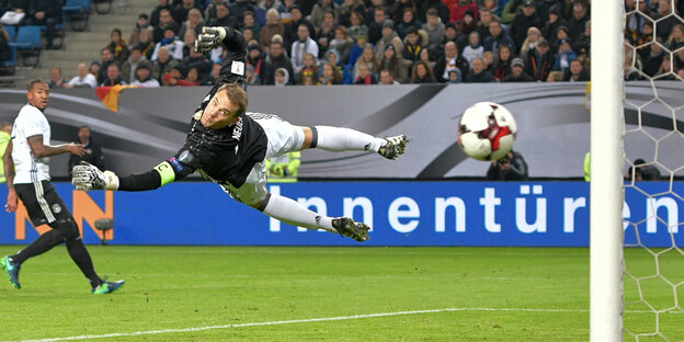Thomas Neuer fliegt waagerecht durch die Luft und lenkt einen Ball vom Tor ab