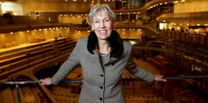 Eine Frau in grauem Anzug steht am Geländer in der Elbphilharmonie