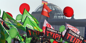 Flaggen von Ceta- und TTIP-Demonstrant*innen wehen vor der Reichstagskuppel