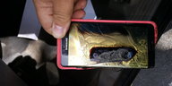 Ein kaputtes Smartphone mit Brandspuren