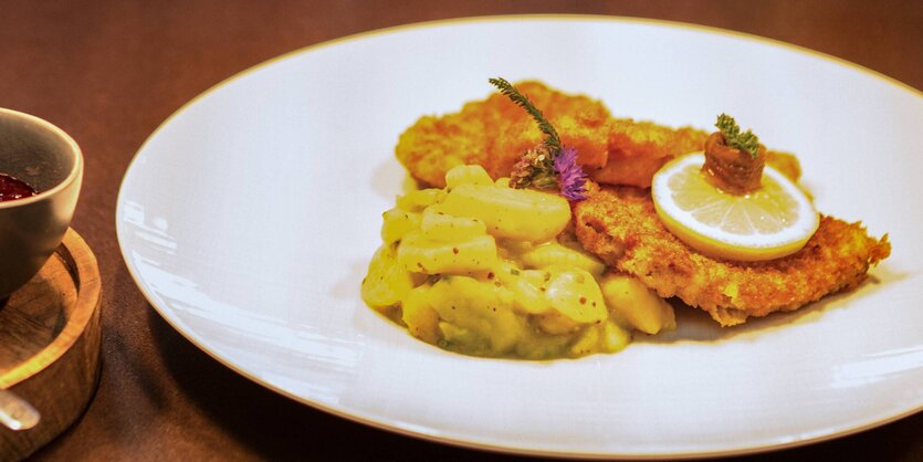 Zwei Wiener Schnitzel mit Kartoffelsalat auf einem weißen Teller