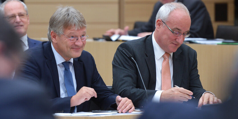 Jörg Meuthen sitzt neben einem Mann