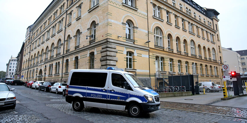 Ein Polizeiauto fährt an einem Haus vorbei