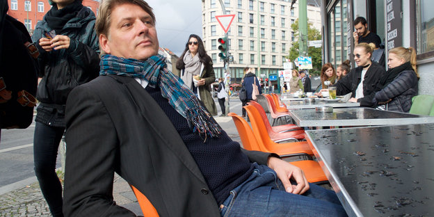 ein Mann sitzt in einem Straßencafé