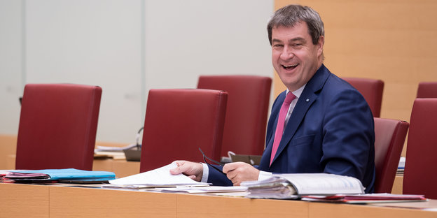 Bayerns Finanzminister Markus Söder (CSU) sitzt lachend an einem Tisch