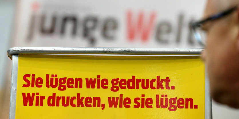 Ein Werbeslogan steht vor dem verschwommenen Logo der "Jungen Welt"