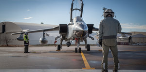 Techniker steht vor einem Kampfflugzeug