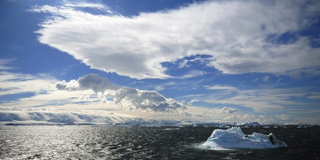 Ein Meer mit Eisbergen, der Himmel ist teilweise bewölkt