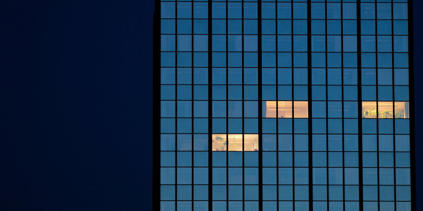 In einem Bürohochhaus leuchten nachts noch drei Büros