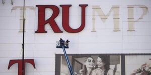 Zwei Männer bauen die Leuchtschrift des Trump-Casinos ab