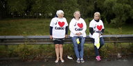 Drei Frauen stehen an einer Leitplanke und tragen T-Shirts mit dem Aufdruck "J'aime Calais"