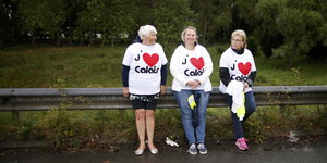 Drei Frauen stehen an einer Leitplanke und tragen T-Shirts mit dem Aufdruck "J'aime Calais"