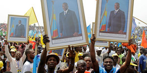 Demonstranten halten eingerahmte Bilder von Joseph Kabila in die Höhe