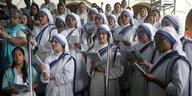 Nonnen in weißen Gewändern mit blauen Streifen singen im Chor
