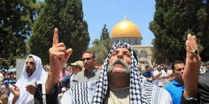 Ein Palästinenser hebt die Hände vor dem Tempelberg