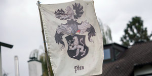 Auf einer Flagge ist ein Wappen und darunter das Wort Plan zu sehenreich Deutschland“, ein Wappen und ein Reitersymbol zu sehen