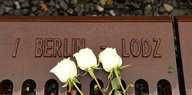 Weiße Rosen auf einer Gedenktafel