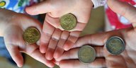 Kinderhände halten Münzen