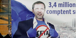 ein Mann mit Stop-Ceta auf der Brust in Superheldenpose