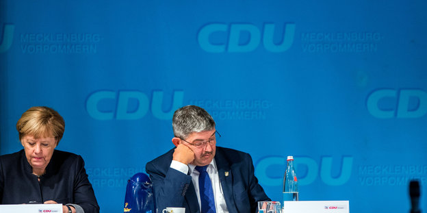Angela Merkel und Sascha Ott von einerm blauen Hintergrund auf dem „CDU Mecklemburg-Vorpommern“ steht