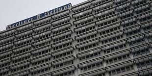 Fassade eines hohen Bürogebäudes. Auf dem Dach der Schriftzug „Berliner Zeitung“