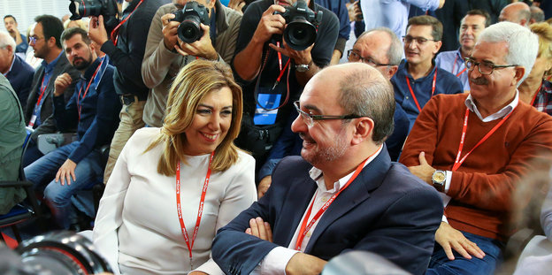 Zwei Politiker werden bei einer Parteiveranstaltung von Fotografen fotografiert.