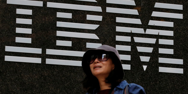Eine Frau läuft am IBM-Logo vorbei