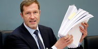 Paul Magnette, Ministerpräsident der Wallonie, hält einen Stapel Papier in den Händen